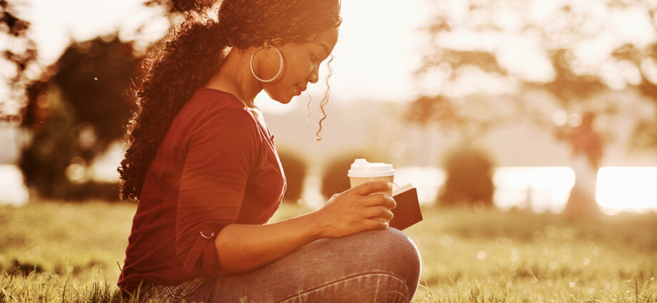 Almost sunset. Cheerful african american woman in the park at summertime.